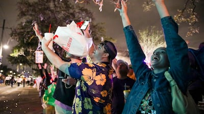 Revellers try to catch Mardi Gras beads at a parade on Monday night in New Orleans. AP