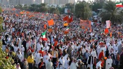 Kuwaiti opposition supporters wave flags during a demonstration against the general election yesterday.
