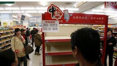 Shoppers look at empty shelves at a supermarket in Beijing, after worried shoppers stripped stores of salt cross China on Thursday in the false belief it can guard against radiation exposure.