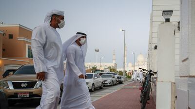 Sheikh Zayed Grand Mosque towers over the neighbourhood in Abu Dhabi as worshippers arrive at Ibn Taymiyyah Mosque for evening prayers on the day President Sheikh Khalifa died. Victor Besa / The National.