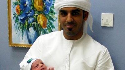 Said Khamis Said Al Ghaithi shows off his new son, the first baby born inAl Ain in 2011.