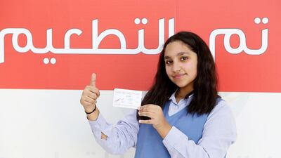Kuwaiti pupil Awrad, 12, shows her vaccination card after receiving her second dose of a Covid-19 vaccination in Kuwait City. People wishing to apply for visas must be fully vaccinated. AFP