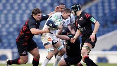 Yannick Caballero, centre, the Castres flanker, is tackled by the Edinburgh defence.