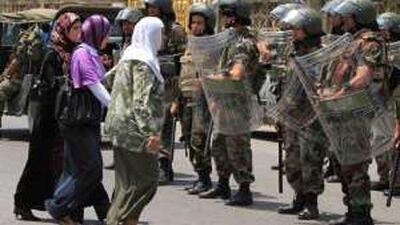 Women walk past soldiers outside a polling station in Sidon yesterday.