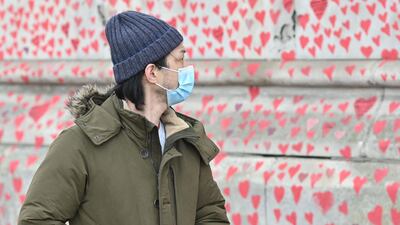 A man pauses to look at the hearts and messages on the wall. AFP