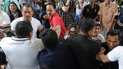 Frustrated Thai voters try to force their way through a line of police officers, including plainclothes officers, blocking the entrance to a polling station as voting was cancelled after anti-government protesters prevented the delivery of election material in Bangkok. AFP