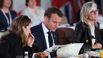 France's President Emmanuel Macron looks at his notes at the G7 Gender Equality Advisory Council Breakfast. Neil Hall / EPA