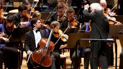 The conductor Vladimir Ashkenazy, right, with the French cellist Gautier Capuçon, front left, and the 118-piece orchestra. Delores Johnson / The National / March 24, 2014