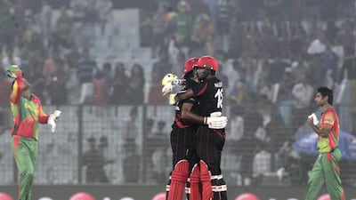Hong Kong’s Haseeb Amjad, left, and Nadeem Ahmed celebrate after they defeated Bangladesh by two wickets during their World Twenty20 match in Chittagong. Bikas Das / AP Photo