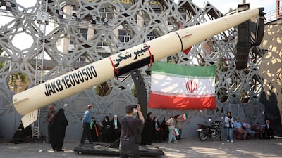 Iranians stand next to a model of a Kheibar missile at a rally in support of supreme leader Mojtaba Khamenei on Thursday. AFP