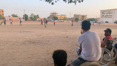 Men watch from the sidelines.