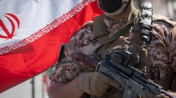 An armed military member of the Islamic Revolutionary Guard Corps stands guard outside a police facility in Tehran. Getty
