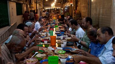 Egyptians enjoy a free iftar on a street in the Zamalek district of Cairo in 2010. The country will host charity Iftar banquets for the first time in two years. Scott Nelson for The National