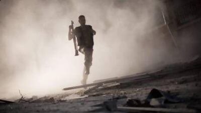 A Free Syrian Army fighter runs after attacking a tank with a rocket-propelled grenade during fighting in the Izaa district in Aleppo.
