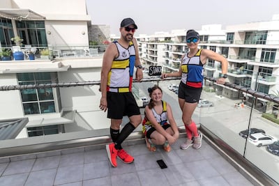 Colin Allin and his wife Hilda, with their daughter Geena, at their “Start” section of their balcony marathon. Antonie Robertson / The National.