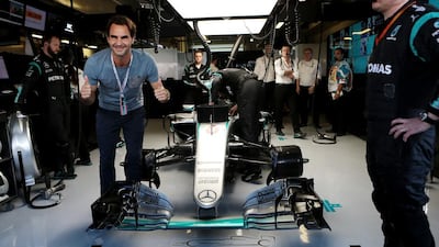 Tennis player Roger Federer poses with the car of Nico Rosberg of Germany and Mercedes-GP ahead of the Abu Dhabi Formula One Grand Prix at Yas Marina Circuit in Abu Dhabi on November 27, 2016. Christopher Pike / The National