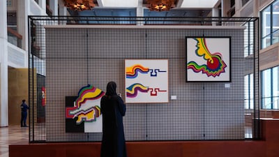 A visitor at Cultural Foundation with Mohammed Chabaa's works. The first retrospective exhibition for the artist outside of Morocco, Visual Consciousness brings together paintings, sculptures, graphic art, interior design models and archival material by Chabaa. Victor Besa / The National