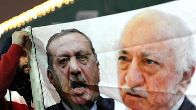 A Turkish protester in Istanbul holds up a banner with pictures of Turkish prime minister Recep Tayyip Erdogan and US-based Turkish cleric Fethullah Gulen during a demonstration against the goverment on December 30, 2013. Ozan Kose/AFP Photo