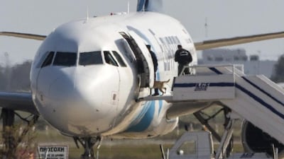 Cypriot security forces take a sniffer dog into an EgyptAir Airbus A320 parked at the tarmac of Larnaca airport after the six-hour hijacking of the plane came to an end on March 29, 2016. Behrouz Mehri/ AFP Photo