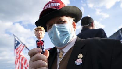 A supporter of US President Donald Trump holds a pen in his likeness outside Walter Reed National Military Medical Centre in Bethesda. Bloomberg