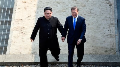 North Korean leader Kim Jong-un, left, and South Korean President Moon Jae-in cross the military demarcation line at the border village of Panmunjom in the Demilitarised Zone on April 27, 2018. AP