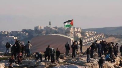 Palestinians, together with Israeli and foreign activists, stand near newly-erected tents in an area known as E1 in front of an illegal Israeli settlement, Ma'aleh Adumim, near Jerusalem