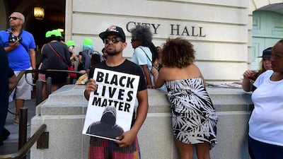 An activist holds a Black Lives Matter poster on the steps of Los Angeles City Hall (AFP / Frederic J. BROWN)