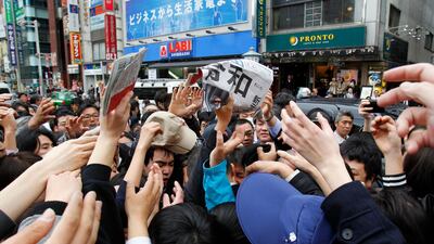 People jostle to grab a copy of extra edition of a local newspaper reporting the name of new era “Reiwa”. AP