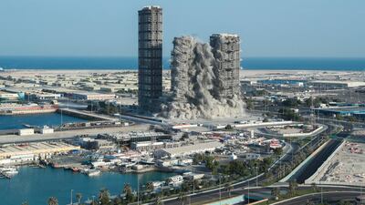 The buildings collapse in a controlled operation sending debris into a cordoned off port area