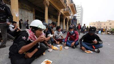 Iraqi protesters take a rest and eat during a protest at Al Rasheed street in central Baghdad. EPA