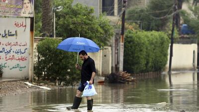 An Iraqi man wades through a flooded street after heavy rains in Baghdad on November 5, 2015. Karim Kadim/AP Photo