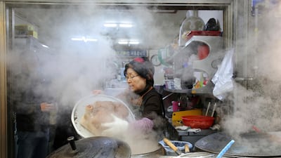 A woman cooks an Ox head outside her restaurant at a market in Gangneung, South Korea. Gangneung is one of the venues of the 2018 Winter Olympics. Aaron Favila / AP Photo