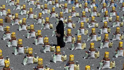 A woman walks between food rations provided by a local charity to conflict-affected people in Sanaa. EPA