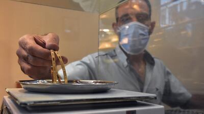 A jeweller weighs gold on a scale at his shop in the old city of Damascus, Syria. In Syria, demand on gold dropped because of the decline in the exchange rate of the Syrian pound against the US dollar. EPA