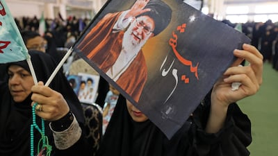 A woman in Tehran holds an image of late supreme leader Ayatollah Ali Khamenei. The Iranian capital is among the cities that will hold a mass funeral event for the assassinated leader. AFP