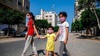 Children cross an empty street amid the lockdown imposed to limit the spread of the pandemic in Gaza City. AFP