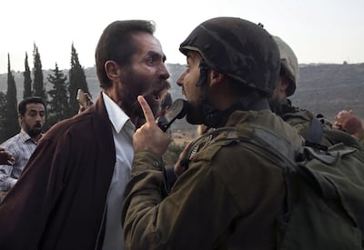 A Palestinian man argues with an Israeli soldier during clashes over an Israeli order to shut down a Palestinian school in the town of as-Sawiyah, south of Nablus in the occupied West Bank on October 15. Photo: AFP