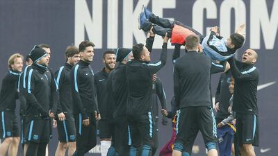 FC Barcelona players lift one of the children who slipped through the ground’s security system and entered the pitch during a training session at the Joan Gamper sports complex in Barcelona, northeastern Spain, 15 March 2016. FC Barcelona will face Arsenal FC in a Uefa Champions League’s round of 16 second leg match on 16 March. EPA/Andreu Dalmau