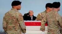 President Donald Trump salutes as troops in Delaware carry the remains of Ayad Mansoor Sakat, a US civilian killed alongside two soldiers in Syria. Getty Images / AFP