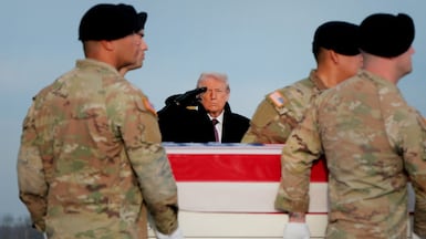 President Donald Trump salutes as troops in Delaware carry the remains of Ayad Mansoor Sakat, a US civilian killed alongside two soldiers in Syria. Getty Images / AFP