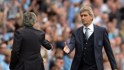Chelsea manager Jose Mourinho, left, shakes hands with Manchester City manager Manuel Pellegrini. Oli Scarff / AFP