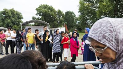 Refugees wait to receive care packages. Christopher Pike / The National