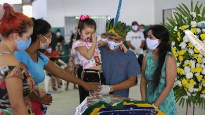 Indigenous people from the Parque das Tribos community mourn besides the coffin of Chief Messias, 53, of the Kokama tribe who died victim of the new coronavirus in Manaus, Brazil, on May 14, 2020. AFP