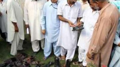 Men identify the shoes of their dead or injured relatives after a suicide attack at an ordinance factory in Wah, near Islamabad.