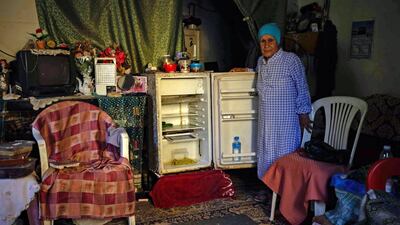 A Lebanese woman stands next to her empty refrigerator in her apartment in the port city of Tripoli. AFP