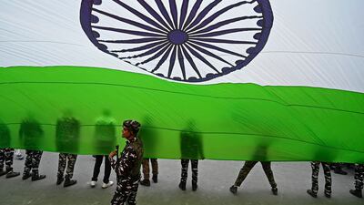 Paramilitary troops with a giant Indian national flag during Independence Day celebrations at Lal Chowk in Srinagar. AFP