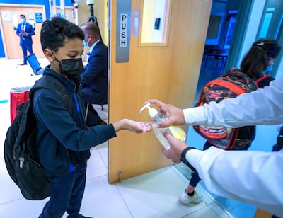 A boy accepts hand sanitiser on his return to the classroom at Gems United Indian School in Abu Dhabi. Victor Besa / The National