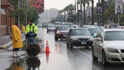Egyptian municipal workers try to clear a street in the capital following heavy rainfall. EPA