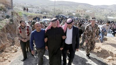 Safi (C), the father of Jordanian pilot Maaz Al Kassasbeh who was killed by ISIL, is surrounded by family members and security forces during a mourning ceremony at the headquarters of the family's clan in the Jordanian city of Karak on February 4, 2015. Khalil Mazraawi/AFP Photo