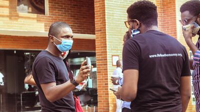 Hamzat Lawal (first on left with a mask), founder of Follow The Money and CEO of Connected Development, chats to his team during a meeting in Abuja. Courtesy CODE/Jide Ojediran